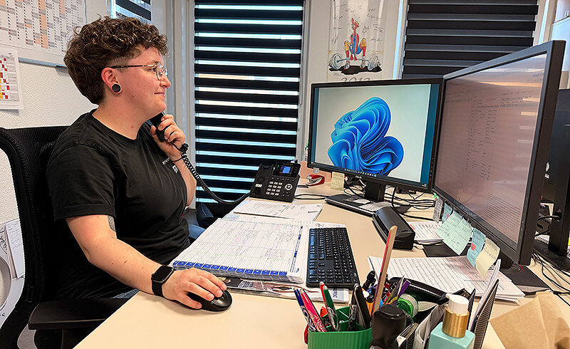 Mitarbeiter im Büro eines Orthopädietechnik-Unternehmens organisiert Aufträge und kommuniziert telefonisch am Arbeitsplatz